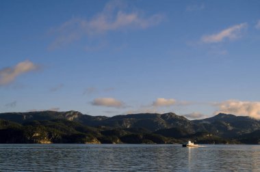 Lusefjord 'daki adanın tepe manzarası. Fiyort boyunca yelken açıyorlar. Norveç 'te turizm. Güneşli bir günde güzel doğa..