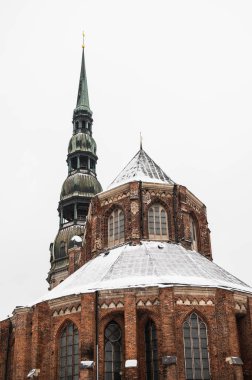 Winter cityscape of Old town of Riga, Latvia. Snow on roof of St. Peter's Church.
