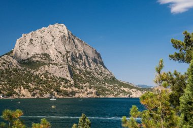 Scenic landscape of blue sea, mountains and green trees. Beautiful summer nature of Crimea. The village of Novy Svet.
