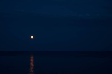 Night landscape. Full moon over the sea. Reflection of the moon path.