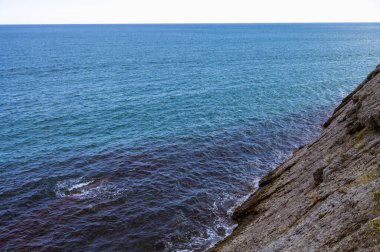 Scenic landscape of blue sea, cloudy sky and huge rock. Beautiful nature.