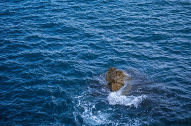 Beautiful nature background. Stone in blue sea top view.