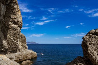 Scenic landscape of blue sea, cloudy sky. Huge rocks and stones on beach. Beautiful nature. The Golitsyn Trail.