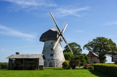 Dutch-type windmill in Araisi, Latvia. Sunny summer day. Old Europe style. Blue sky. Green grass.