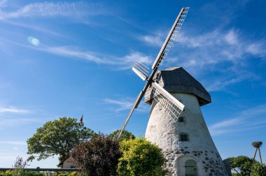 Dutch-type windmill in Araisi, Latvia. Sunny summer day. Old Europe style. Blue sky. Green grass.