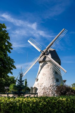 Dutch-type windmill in Araisi, Latvia. Sunny summer day. Old Europe style. Blue sky. Green grass.