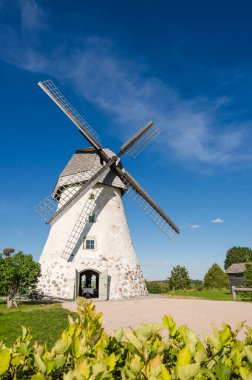 Dutch-type windmill in Araisi, Latvia. Sunny summer day. Old Europe style. Blue sky. Green grass.