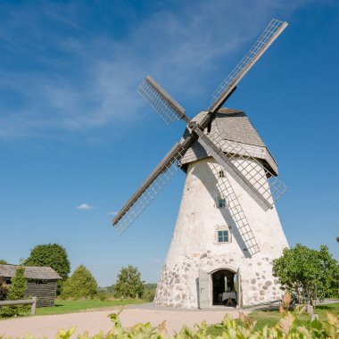 Dutch-type windmill in Araisi, Latvia. Sunny summer day. Old Europe style. Blue sky. Green grass.
