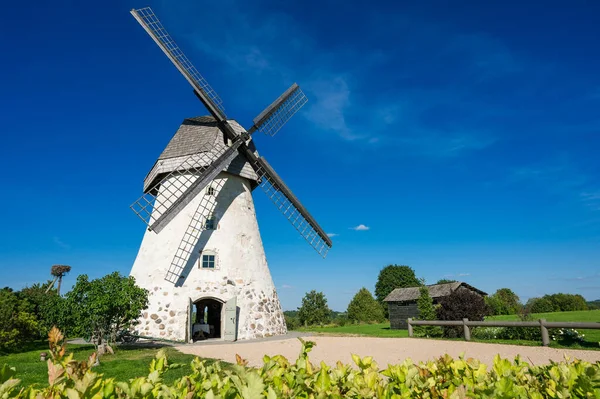 Dutch-type windmill in Araisi, Latvia. Sunny summer day. Old Europe style. Blue sky. Green grass.