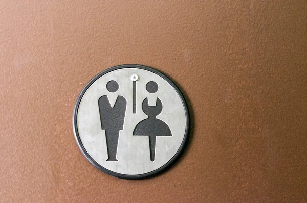 Toilet, wc icon, round wooden white and brown sign on restroom door in the hallway, restaurant, lobby.