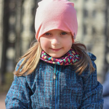 Baharda parkta yürüyüş yapan mutlu bir kız. Parkta yürü. Portre Çocuk 6 yaşında