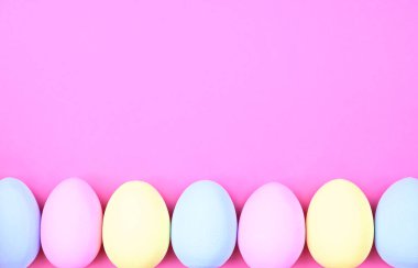 Pembe arka planda çok renkli Paskalya yumurtaları ve fotokopi alanı