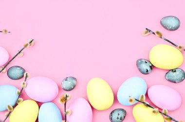 Renkli paskalya yumurtaları ve pembe arka planda söğüt dalları fotokopi alanı ile