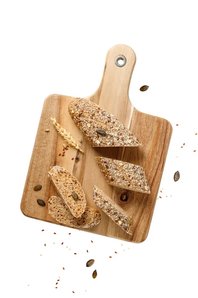 Kabak, ayçiçeği, gelincik ve keten tohumları beyaz arka planda izole edilmiş tahta kesme tahtasının üzerinde. Sağlıklı hamur işleri.