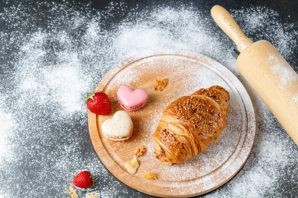 新鲜的烤黄油压碎坚果早餐羊角面包 法国心脏金刚鹦鹉 草莓和碎屑在木板上的深色桌子上面粉 带有复制空间的厨房背景 — 图库照片