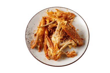 Kemikler ve soslu tavuk ziyanı kırsal tabakta. Akşam yemeğinden sonra yakın plan beyaz arka planda izole edilmiş..