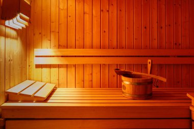 Bankta kaşık olan tahta bir kova. Geleneksel finnish sauna iç dekorasyonu ve aksesuarları. Kopya alanı ile doğal ahşap arkaplan