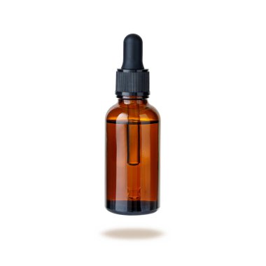Dark brown glass bottle of face serum or essential oil or pharmaceutical tincture flying isolated on white background