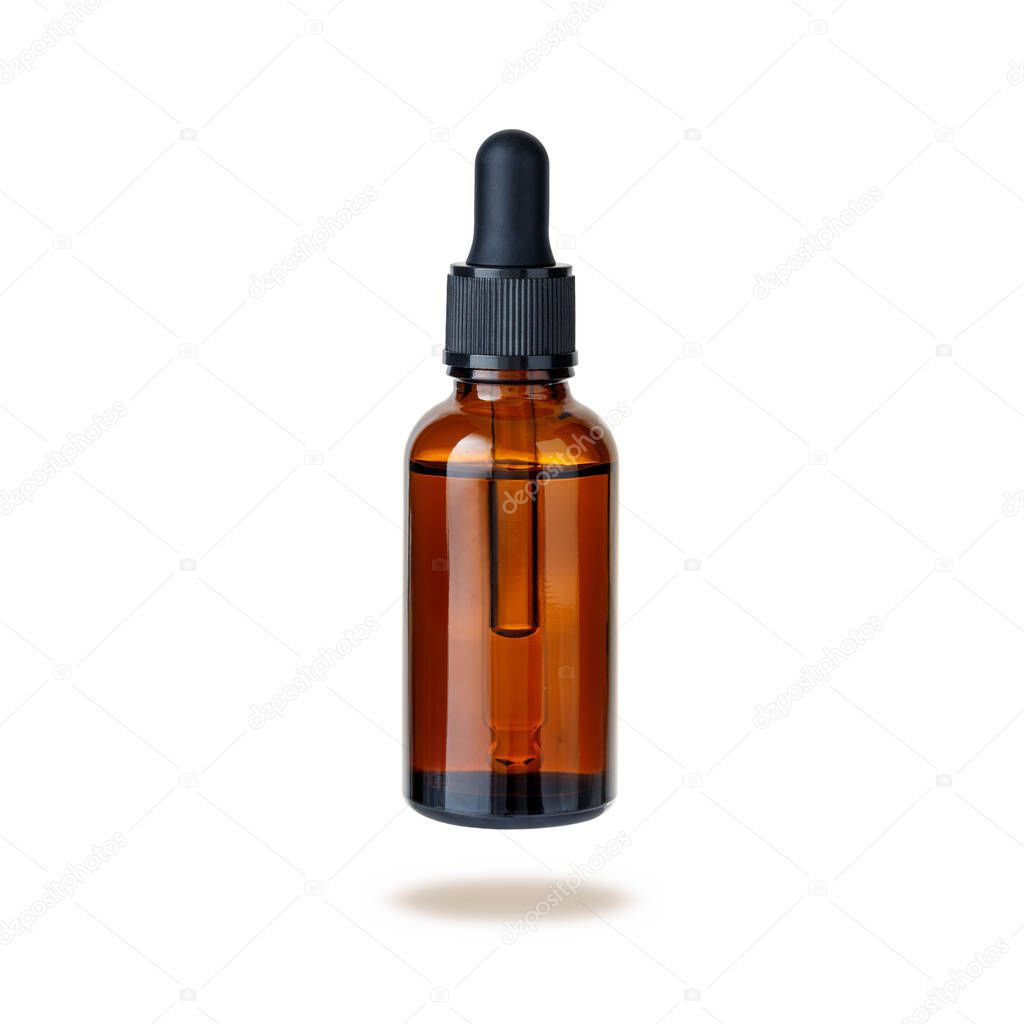 Dark brown glass bottle of face serum or essential oil or pharmaceutical tincture flying isolated on white background