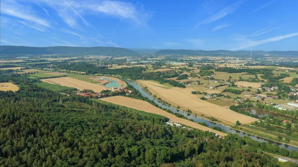 Beautiful summer landscape with river Weser in Germany. Aerial drone view on forest, fields, river and villages on sunny day.