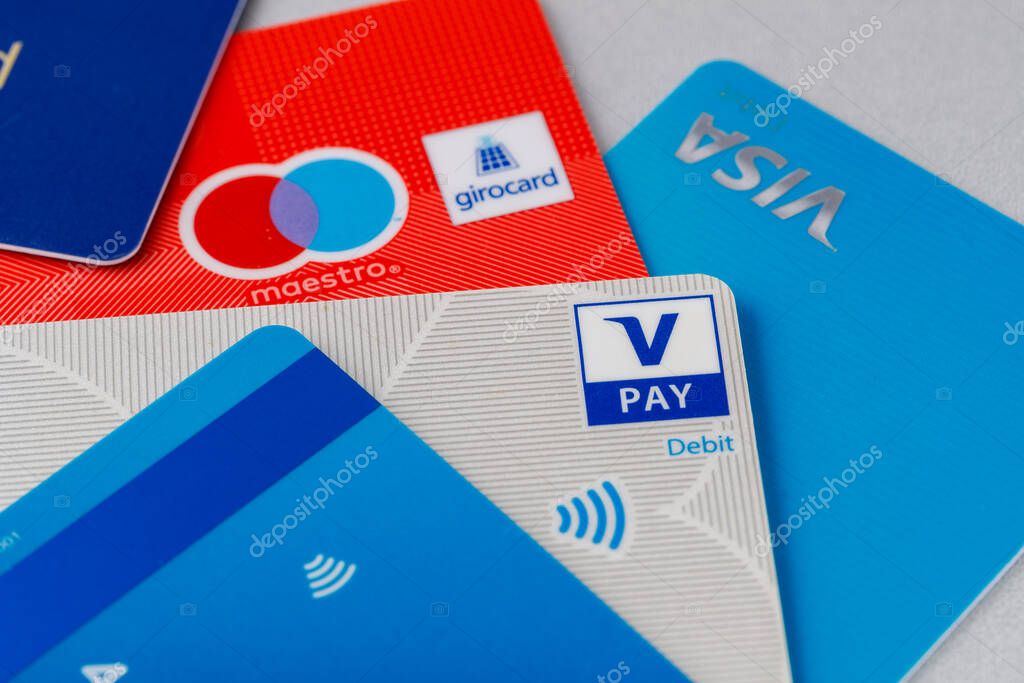 Various cards with payment system icons. Selective focus on V pay sign logo. Giro cards with v pay and maestro option on table.