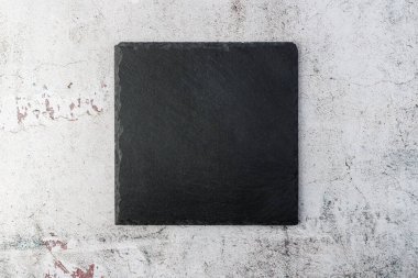 Boş kare siyah tahta, arka planda hafif hasarlı beton. Kopyalama alanı olan tahta.