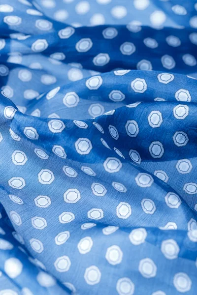 Abstract blue natural silk background. Silk fabric with polka dots pattern closeup.