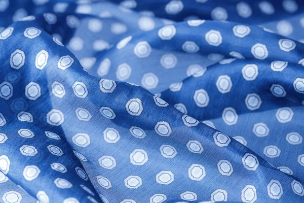 Abstract blue natural silk background. Silk fabric with polka dots pattern closeup.