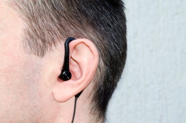 the earphone in an ear of the man clipart