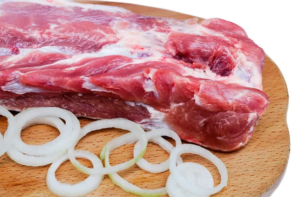 Ruwe vlees met uien op een bord close-up — Stockfoto