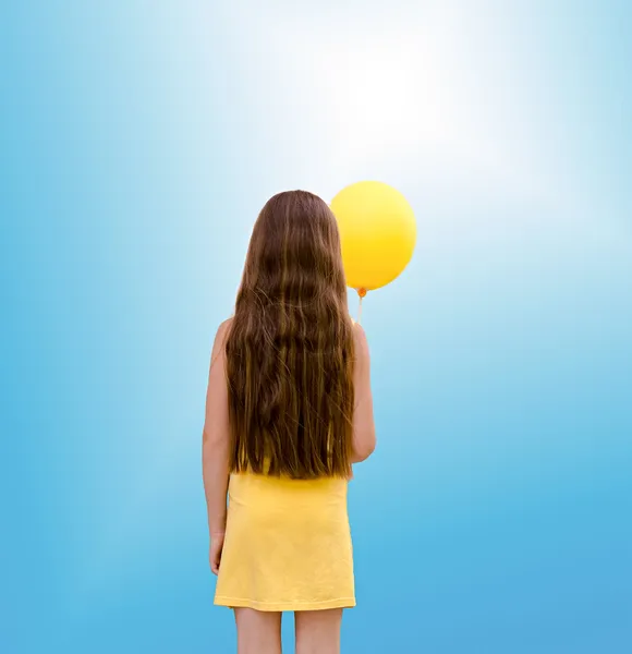 Barnet flickan med en ballong från en back Royaltyfria Stockfoton