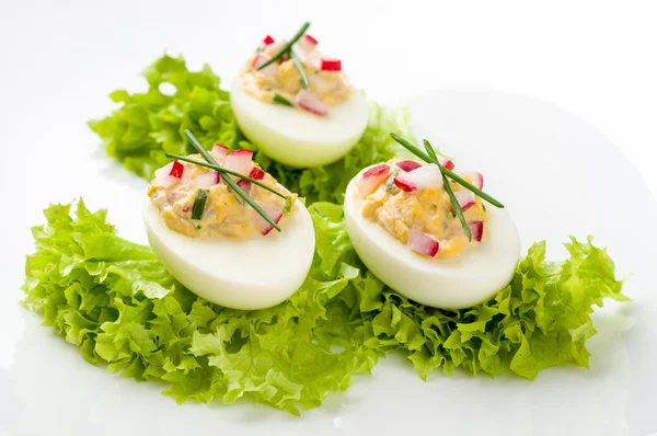 Stuffed eggs on lettuce with chives garnish — Stock Photo, Image