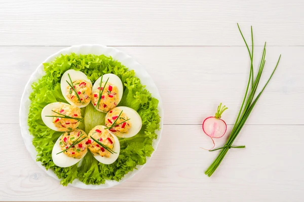 Stuffed eggs on lettuce with chives garnish — Stock Photo, Image