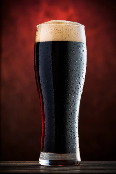 Glass of cold dark beer on wooden table — Stock Photo, Image