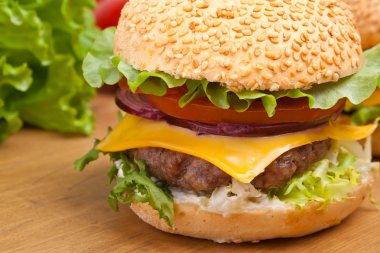 ahşap bir masa üzerinde büyük lezzetli peynirli burger
