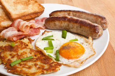 Klasik kızartılmış yumurta, kızarmış patates ve domuz pastırması ile plaka