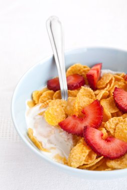 bowl of cornflakes and strawberries with yogurt 