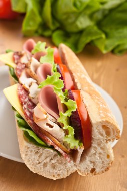 Half of long baguette sandwich with meat, vegetables clipart