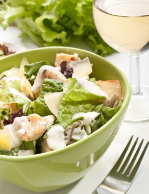 bir kadeh beyaz şarap ile geleneksel Sezar salatası