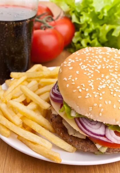 Big tasty cheeseburger with french fries and ingredients on a wo — Stock Photo, Image