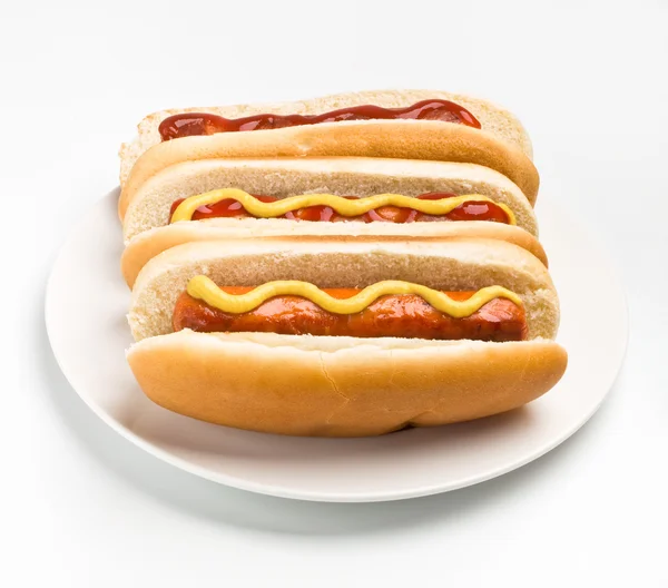 Três cachorros-quentes clássicos com mostarda e ketchup — Fotografia de Stock