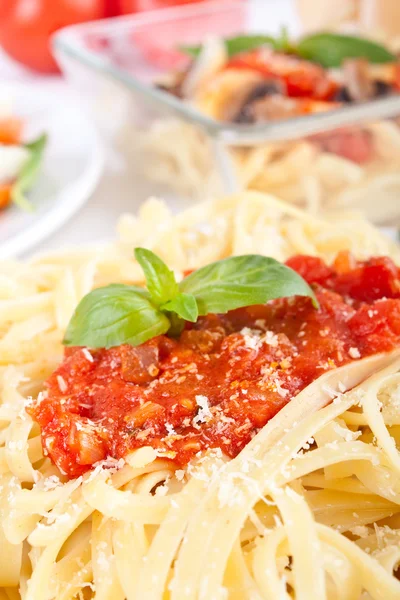 Za porci těstovin linguine s lahodnou rajčatová omáčka, bazalka — Stock fotografie