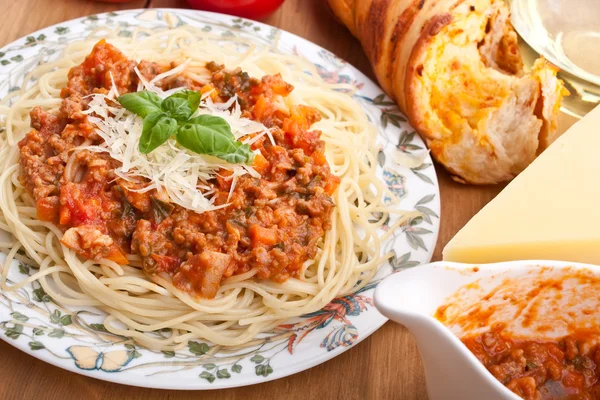 Servering av spaghetti med köttfärssås, ost och basilika — Stockfoto