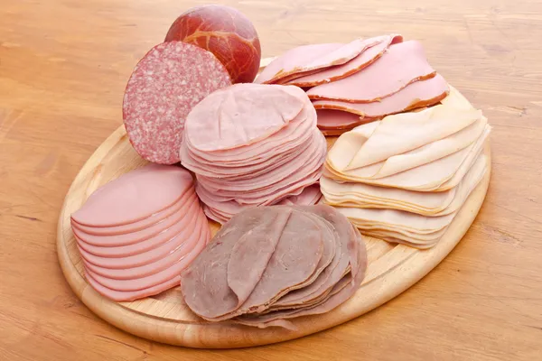 Grote groep van dun gesneden vlees op een snijplank — Stockfoto