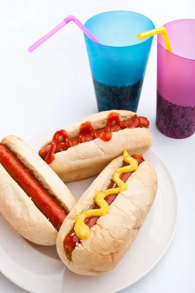 Tre hot dog su un piatto e bevande — Foto Stock