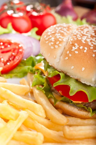 Cheeseburger met frietjes en ingrediënten — Stockfoto