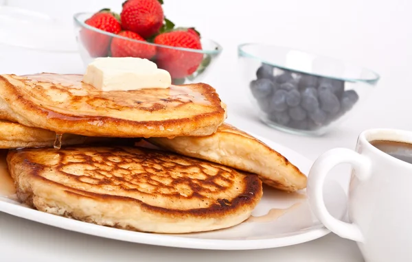 Stack of pancakes with butter and slathered with syrup — Stock Photo, Image