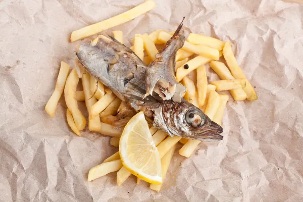Fisch und Pommes auf einem Stück braunem Bastelpapier — Stockfoto