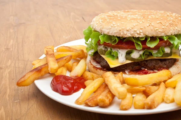 Big tasty cheeseburger with french fries — Stock Photo, Image