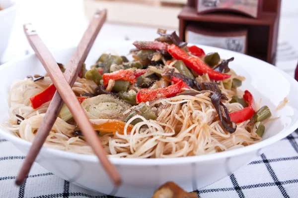 Rice noodles with vegetables and pair of chopsticks — Stock Photo, Image